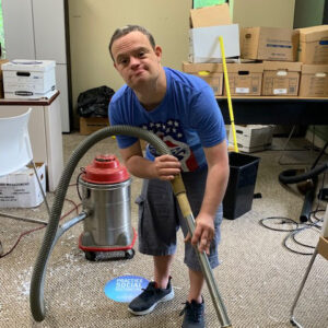 a PELS client vacuuming the floor