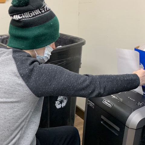 a PELS client working at a paper shredder